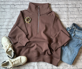 This is a Jordy Boxy Half Zip Pullover in the color Java.  It is displayed as a flat lay.