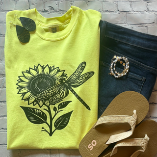 This is the Sunflower Dragonfly Graphic Tee in the color of neon lemon. The brand is Comfort Colors. It is presented as a flat lay.