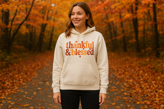 Woman wearing a 'thankful & blessed' hoodie in an autumn forest. Jerzee Hoodie in ivory 