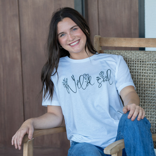 This is the Wild Soul Graphic Tee in the color white. The brand is Bella Canvas.